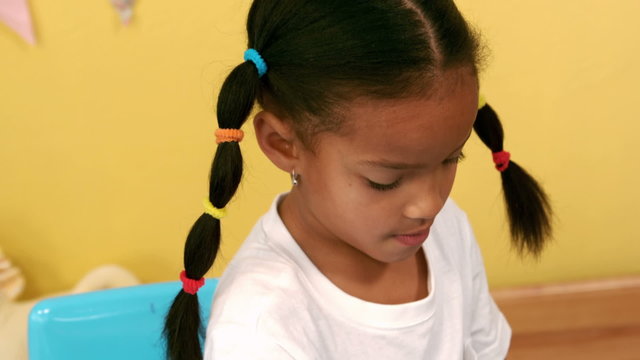 Smiling girl colouring her drawing