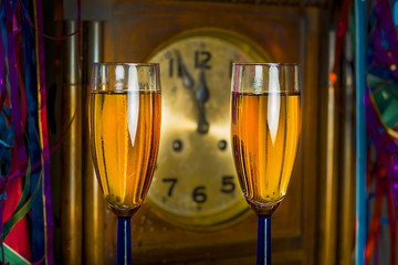 Glasses of champagne on the background of the old clock - obrazy, fototapety, plakaty