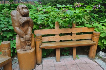Park bench with a wooden sculpture of the monkey