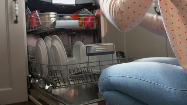 Pretty Young Woman Using The Dishwasher