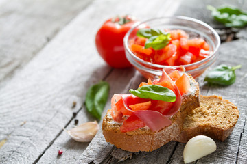 Bruschetta and ingredients on rustic wood background