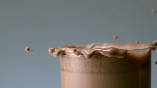 Cookie falling in glass of chocolate milk