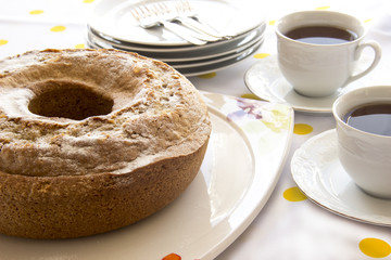 Homemade ring cake with icing sugar and cup of tea for teatime in afternoon
