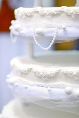 Wedding cake decorated with white lace and flowers
