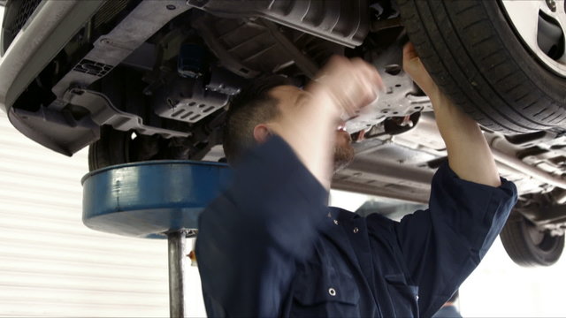 Handsome mechanic reparing a car
