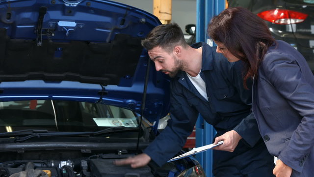 Mechanic talking to a female customer