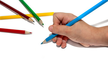 Children's hand with colored pencils