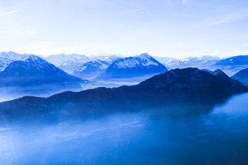 Fototapeta na wymiar Panoramic skyline view of snow-capped mountains over lake Lucern