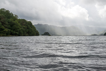 Mountain and sunrays over large lake