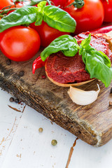 Tomato sauce and ingredients on white wood background