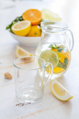 Lemonade and ingredients on white wood background