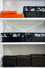 orange towel and a basket on a white shelf