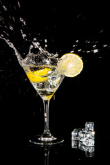 cocktail with splash and  lime isolated on black