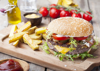 Burger, hamburger with frech fries, ketchup, mustard and fresh vegetables
