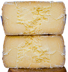 cheeses cut in two pieces isolated on white background, for sale in a market in the apulia