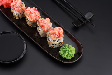 Premium quality sushi rolls with ginger wasabi and soy sauce over black background