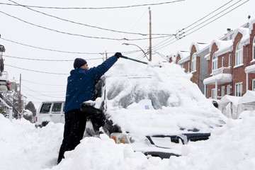 Man with a snow shovel. Snowfall in the city.