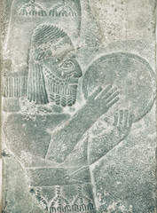 Musician with percussion instrument of Middle East. Assyrian relief