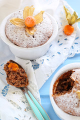 have broken chocolate muffin in ceramic forms sprinkled with pow