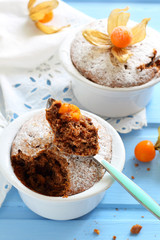 chocolate muffins in ceramic forms sprinkled with powdered sugar