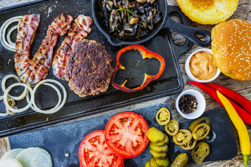 Hamburger, homemade hamburger, bacon and grilled vegetables