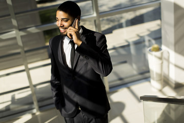 Handsome young black man with mobile phone in the office