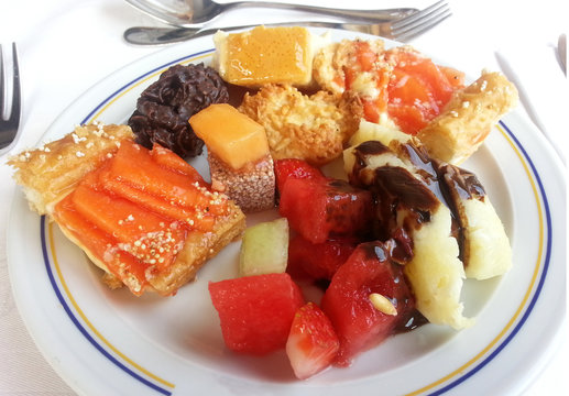 Dessert plate with assorted sweets, cookies, tarts and fruits at an all-inclusive resort buffet