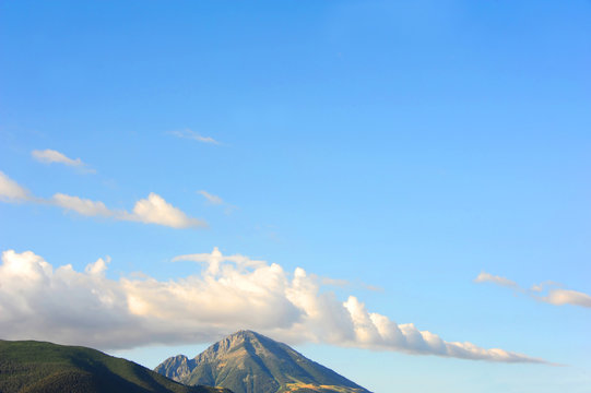 Background imagge shows mountain Peak in soft light of evening sky.  Clouds hug close to mountain in Paradise Valley, Montana.