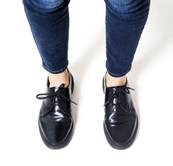 Woman feet wearing black laced shoes closeup