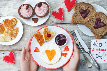 Men's hands hold a breakfast for Valentine's Day