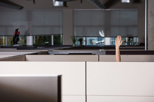hand raised asking for help in office cubicle
