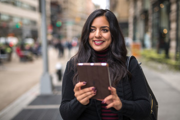 Indian woman in city using tablet computer
