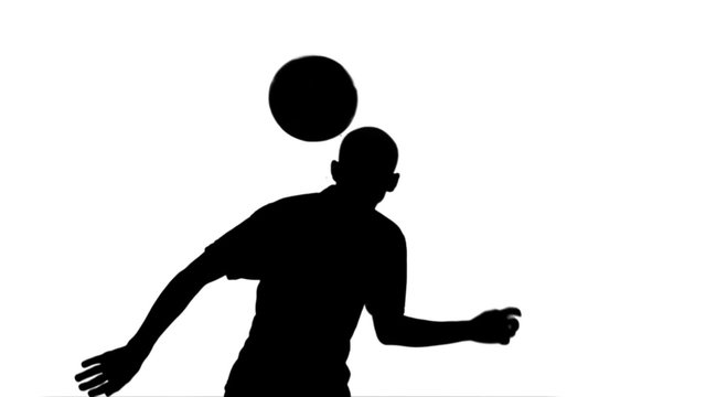 Silhouette of football player heading the ball 