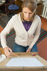 A young girl paints on an easel in the studio of the artist