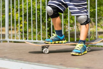 Boy with One Foot on Skateboard on Top of Ramp