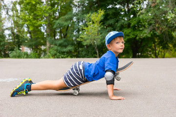 Young Boy Lying on Skateboard in Paved Lot
