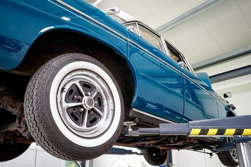 Ein blaues Auto auf einer Hebebühne in einer Kfz-Werkstatt