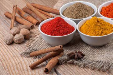 Spices in bowls on wooden background