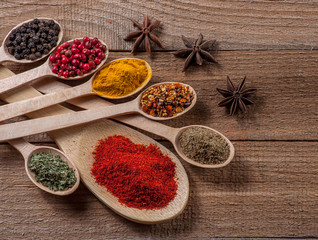 Fototapeta premium Spices in spoons, wooden background