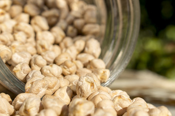 Dry white chickpeas get out of an overturned glass jar
