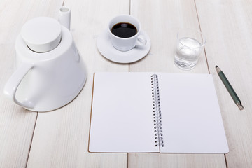 Draufsicht eines kreativen Arbeitstisch mit einer Tasse frischen Kaffees