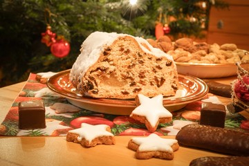 Angeschnittender  Marzipanstollen vor einer Weihnachtstanne