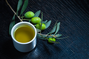 Branch of olive tree with green olive berries and cap of fresh o