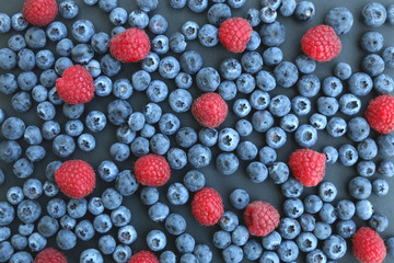 Blueberries and raspberries on dark background. Top view. 