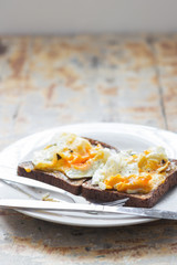 Close up of mashed poached eggs on a rustic kitchen table