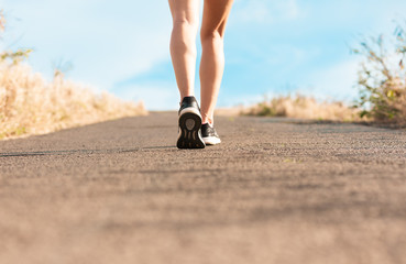 Woman walking on a path. (Fitness concept)
