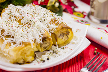 Cheese Roll Pie with Glass of Yogurt on Red Table with Christmas Tree Decoration