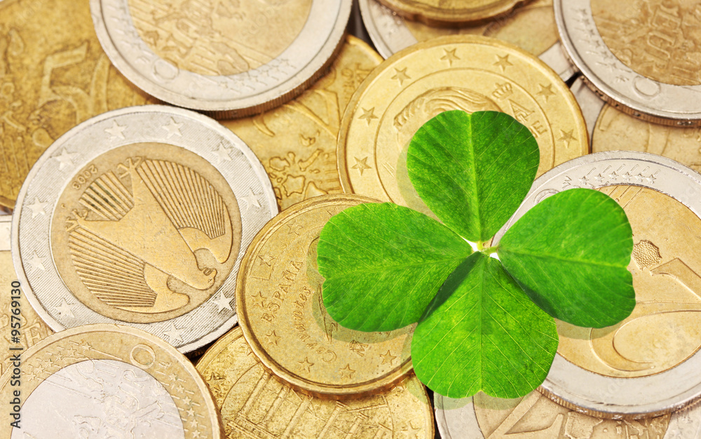 Sticker clover leaf and euro coins, close-up