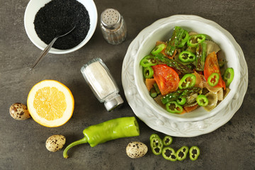 Roasted asparagus and tasty colorful pasta with vegetables, spices in bowl on colorful background