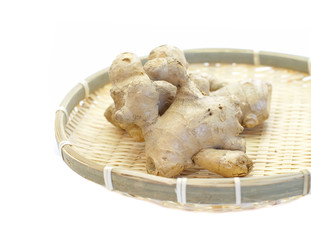 Fresh organic ginger in bamboo tray on white background